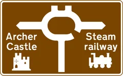 Roundabout ahead leading from a motorway exit slip road to the tourist attractions shown — UK road sign