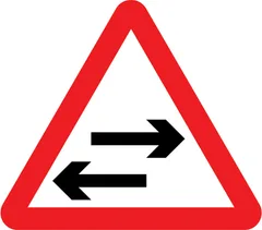 Two-way traffic on route crossing ahead — UK road sign