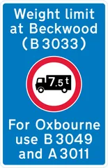 Location of a weight restriction ahead with indication of an alternative route — UK road sign